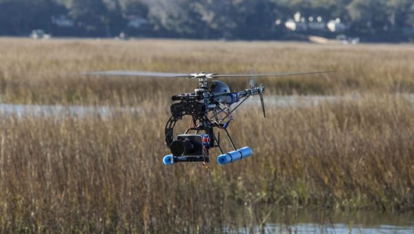 helicopter drone with camera flying over water